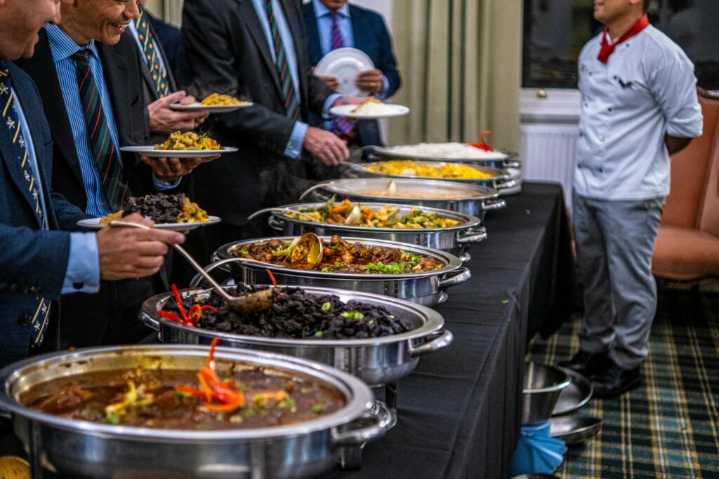 Business professionals in suits enjoy a diverse buffet lunch selection at a formal event.